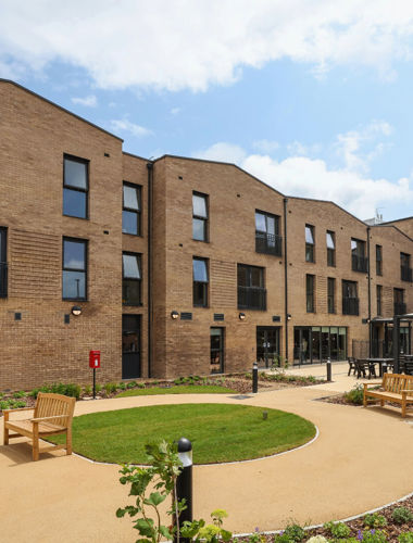 An image of the garden area of Spinnaker View, featuring benches and grassy areas