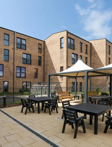 An image of the exterior courtyard at Spinnaker View with tables and chairs under canopies.